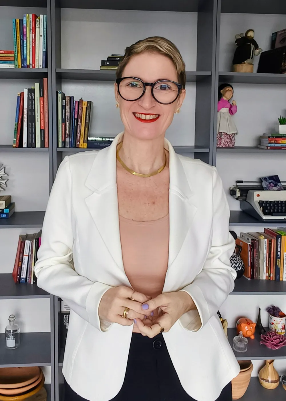 Ariane Angioletti, advogada, em seu escritório diante de uma estante de livros